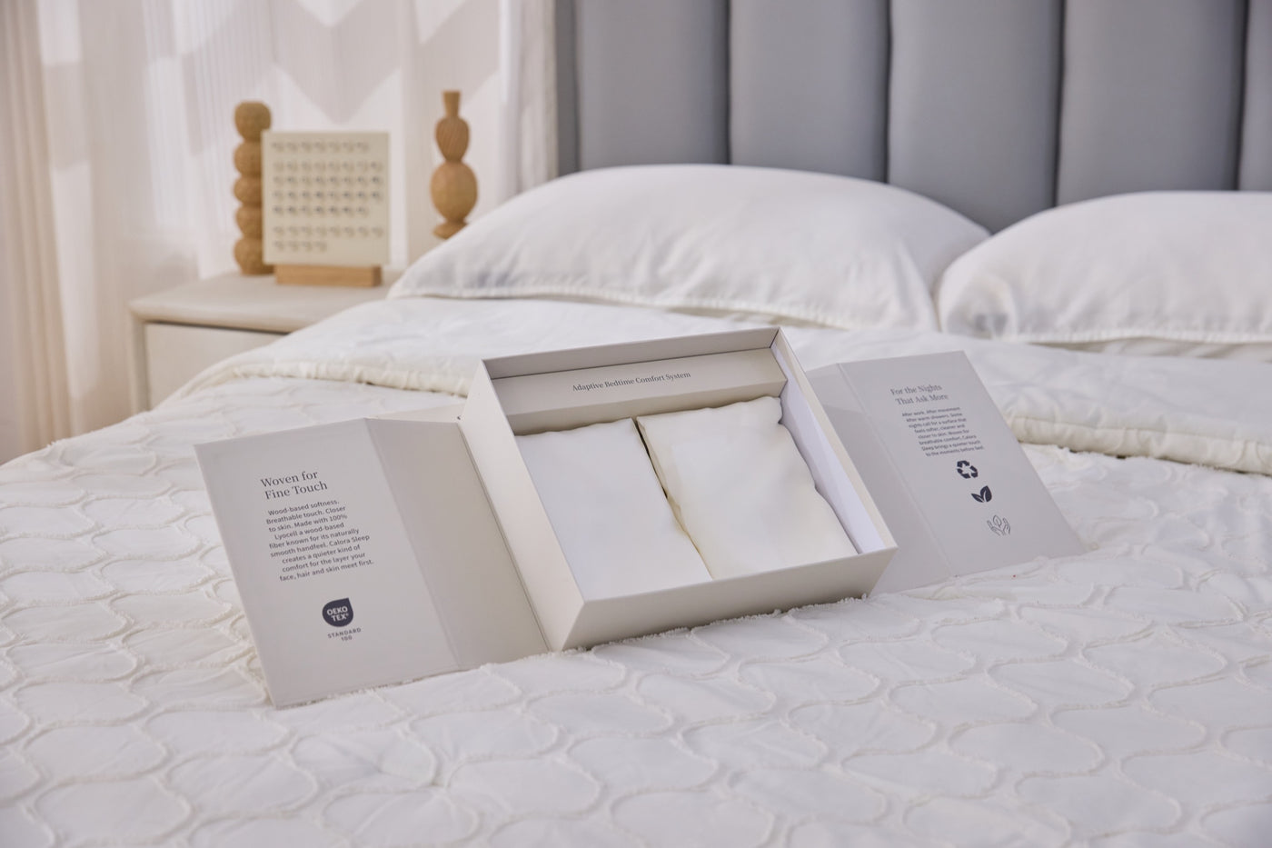 Open Calora Sleep premium gift box with two ivory pillowcases on a bed