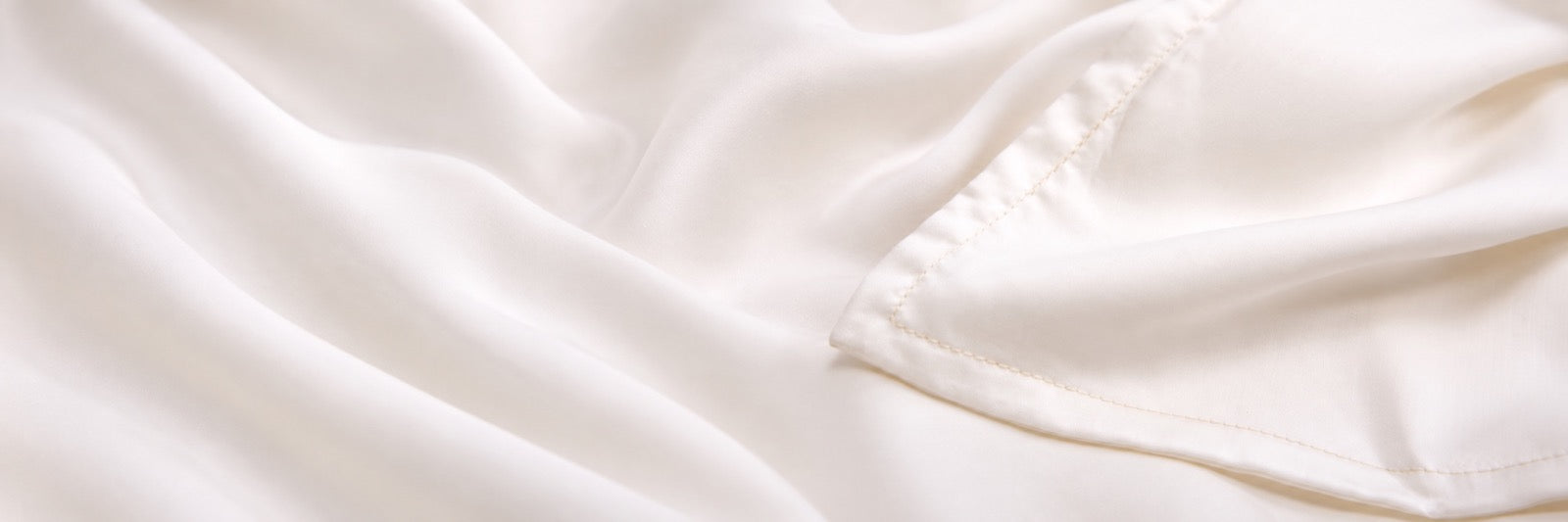 Close-up of the actual ivory lyocell fabric, showing its fine weave and soft folds